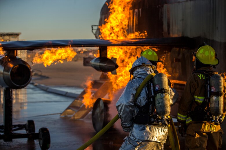 U.S. Marines with Aircraft Rescue and Firefighting (ARFF), Headquarters and Headquarters Squadron (H&HS), Marine Corps Air Station (MCAS) Yuma conduct hand line drills during live burn training on MCAS Yuma, Ariz., June 25, 2019. Hand line drills focus on techniques to push fuel fires away from aircraft, ARFF Marines train monthly to enhance their readiness when responding to emergencies on the flight line. (U.S. Marine Corps photo by Lance Cpl. John Hall)