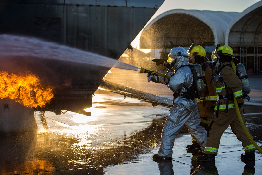 U.S. Marines with Aircraft Rescue and Firefighting (ARFF), Headquarters and Headquarters Squadron (H&HS), Marine Corps Air Station (MCAS) Yuma conduct hand line drills during live burn training on MCAS Yuma, Ariz., June 25, 2019. Hand line drills focus on techniques to push fuel fires away from aircraft, ARFF Marines train monthly to enhance their readiness when responding to emergencies on the flight line. (U.S. Marine Corps photo by Lance Cpl. John Hall)