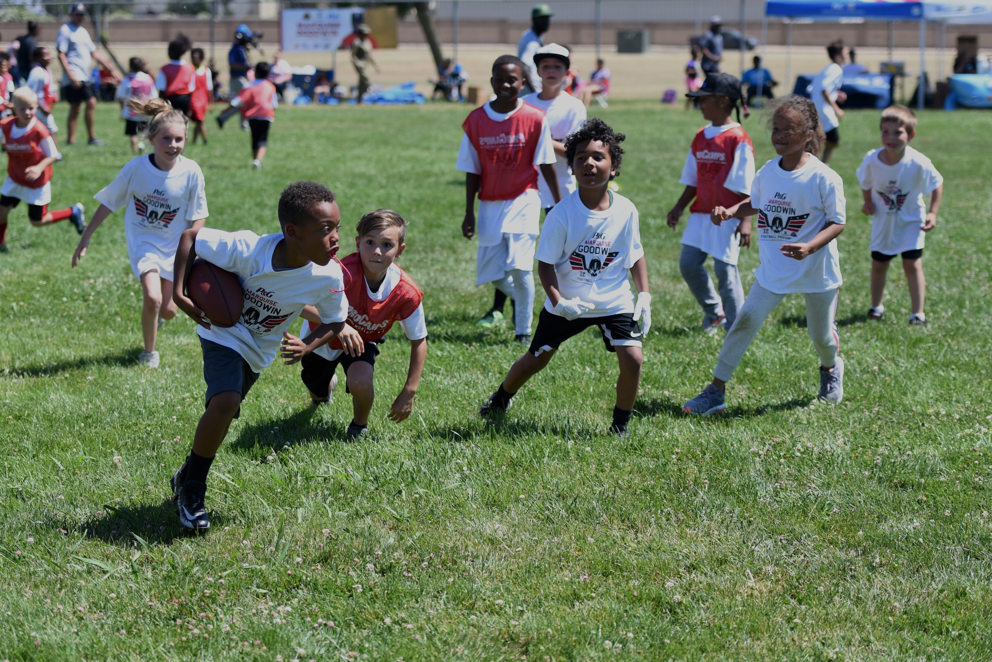 Children who live on base participate in a youth football ProCamp June 19, 2019, at Travis Air Force Base, California. The camp was sponsored by Procter & Gamble and the Defense Commissary Agency. Marquise Goodwin, San Francisco 49ers wide receiver, taught the young athletes about football, team work and respect. (U.S. Air Force photo by Airman 1st Class Cameron Otte)