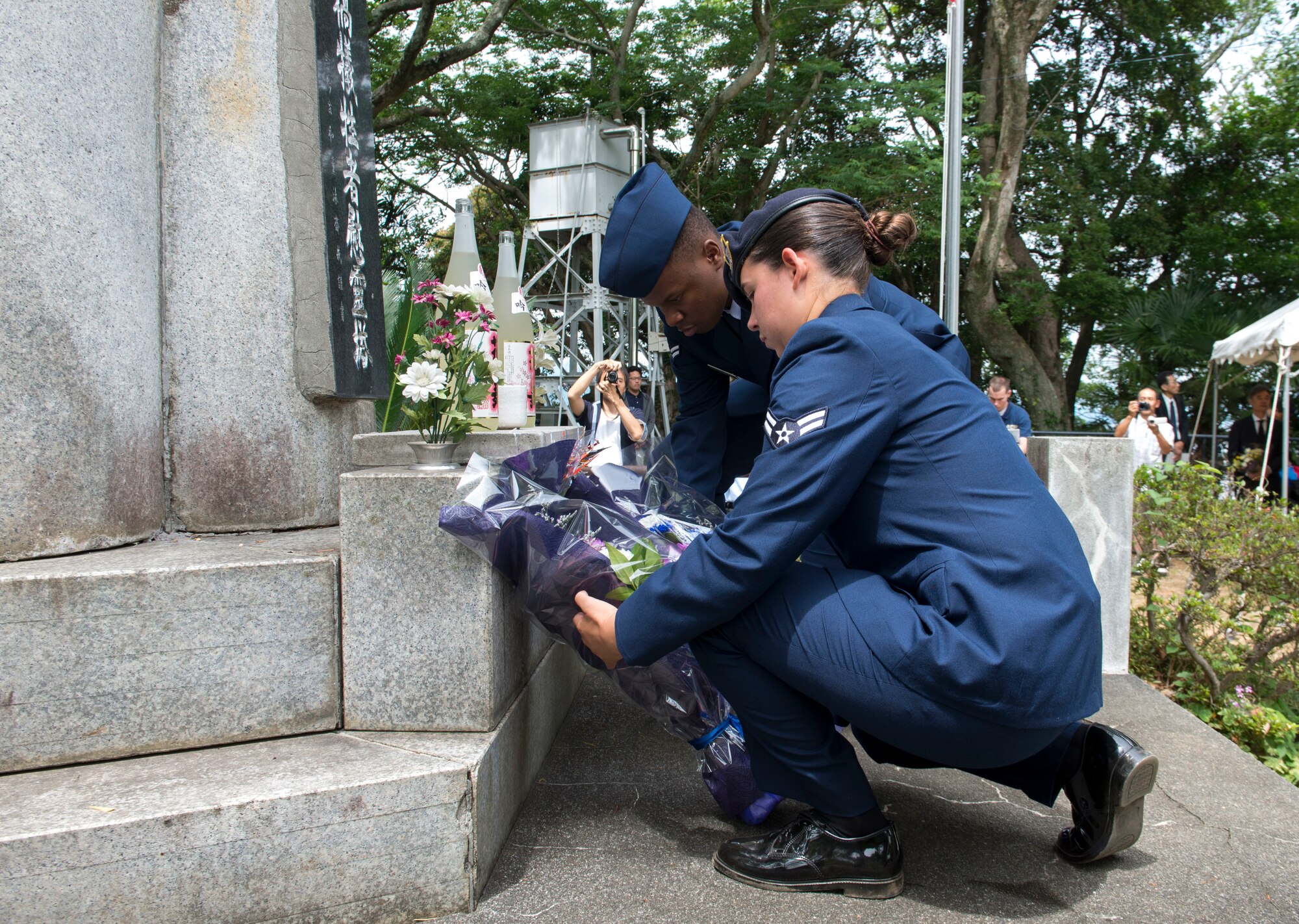 Airman 1st Class Veronica Hambel, 374th Security Forces Squadron patrolman (front), and Airman 1st Class John Mutiso, 374th Maintenance Operations Squadron documentation apprentice, lay flowers at the base of the Japanese memorial statue during the 47th annual B-29 Memorial Ceremony at Sengen Shrine in Shizuoka City, Japan, June 22, 2019.