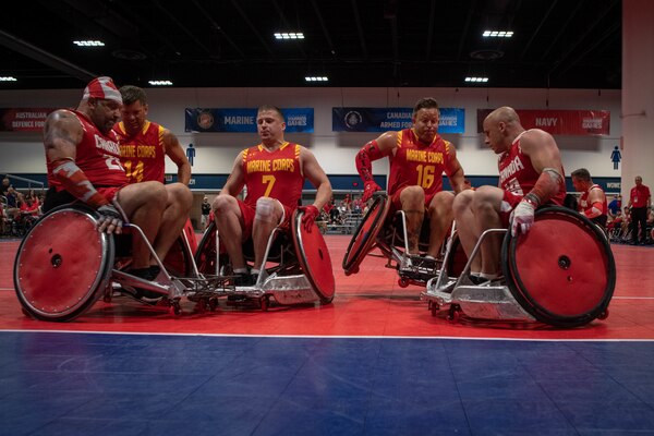 Group photo of athletes of Team Marine Corps and Canada colliding at the end zone during the 2019 DoD Warrior Games wheelchair rugby preliminaries in Tampa, Florida.