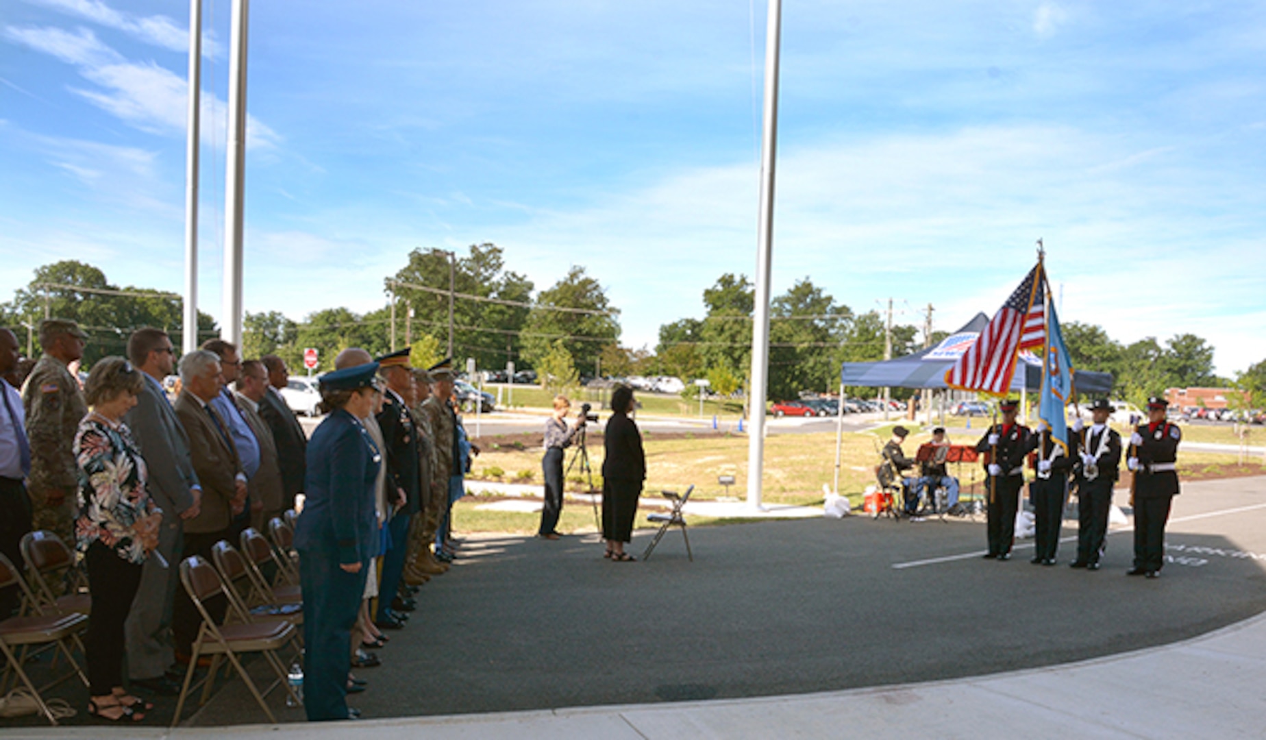 Audience stands for color guard at ribbon cutting ceremony