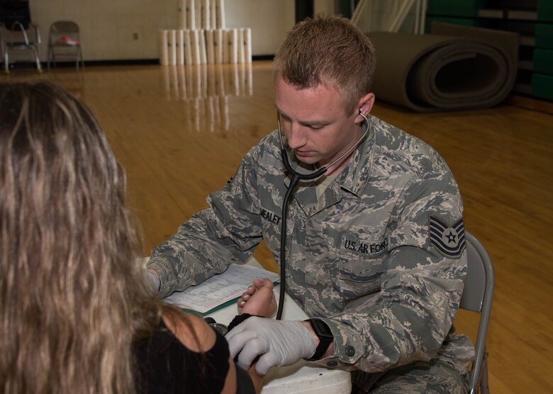 Air National Guard Tech. Sgt. Sean Mealy, the medical noncommissioned officer in charge for the DAEOC Tri-State Innovative Readiness Training (IRT) 2019, checks a patient’s blood pressure during triage June 18, 2019 during the DAEOC Tri-State Innovative Readiness Training (IRT) 2019 mission at Ballard Memorial High School, Barlow, Ky.