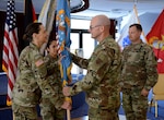 Air Force Maj. Gen. Allan Day, DLA Logistics Operations director, presents the colors to Army Col. Krista Hoffman, incoming DLA Europe & Africa commander, during a change of command ceremony June 26 in Kaiserslautern, Germany, as Army Master Sgt. Roxanna Carr (middle left), DLA E&A senior enlisted leader, and Army Col. Theodore Shinkle (right), outgoing commander, look on.