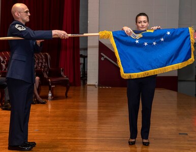 Col. Donna Turner, commander of the newly named Air Force Services Center, unfurls her unit's new flag at a special ceremony June 25 at Joint Base San Antonio-Lackland. The Air Force Installation and Mission Support Center formally re-designated AFSVC and the Air Force Installation Contracting Center-- two of its primary subordinate units -- to bring them in line with Air Force naming conventions.