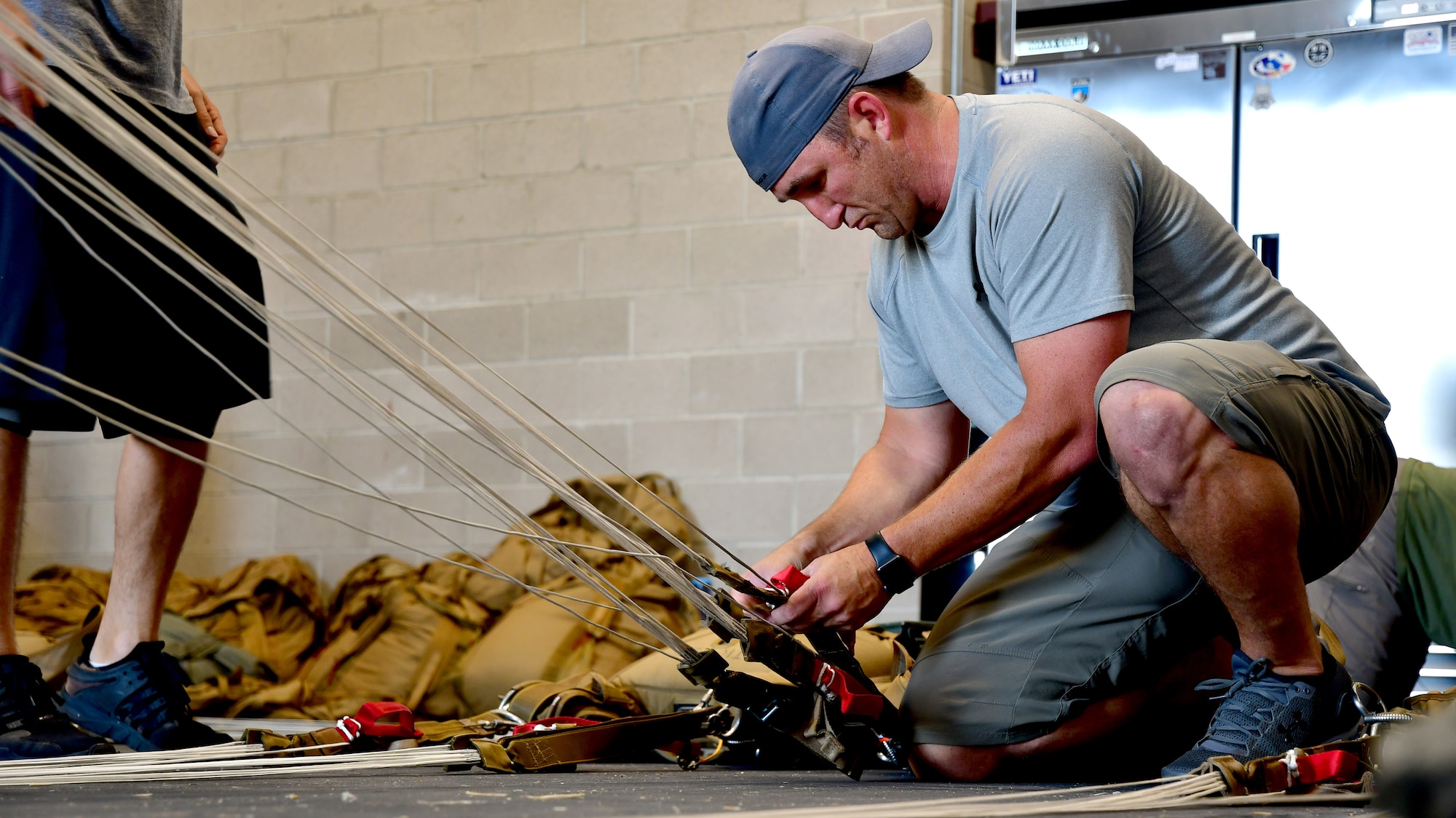 A U.S. Air Force parachute rigger from the 306th Rescue Squadron inspects a parachute prior to packing it for pararescuemen who are accomplishing five-level upgrade jump training at the Marana Regional Airport, Ariz., June 26, 2019.