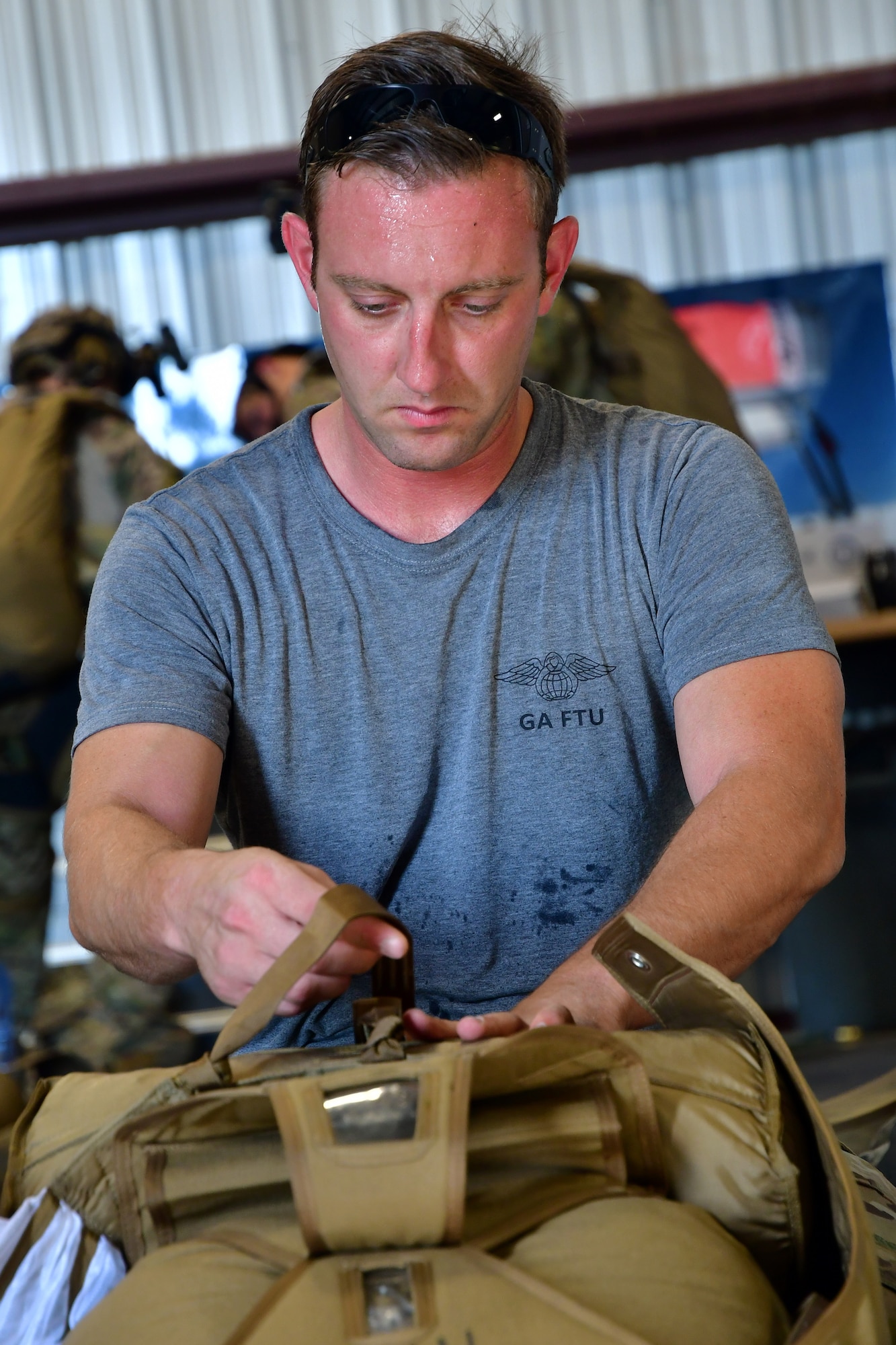 A U.S. Air Force parachute rigger from the 306th Rescue Squadron packs a parachute for pararescuemen accomplishing five-level upgrade jump training at the Marana Regional Airport, Ariz., June 26, 2019.