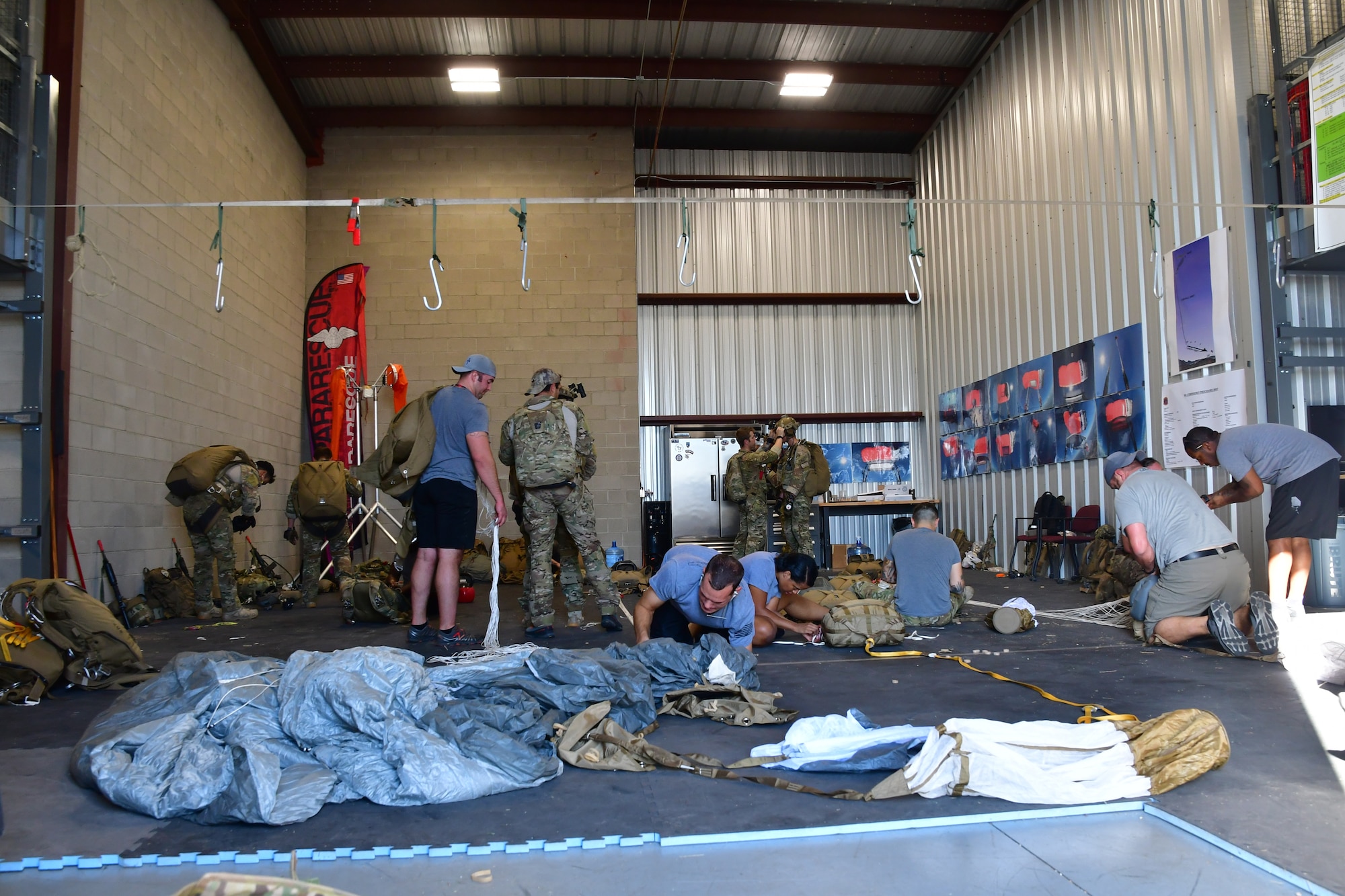U.S. Air Force parachute riggers from the 306th Rescue Squadron pack parachutes for pararescuemen accomplishing five-level upgrade jump training at the Marana Regional Airport, Ariz., June 26, 2019.