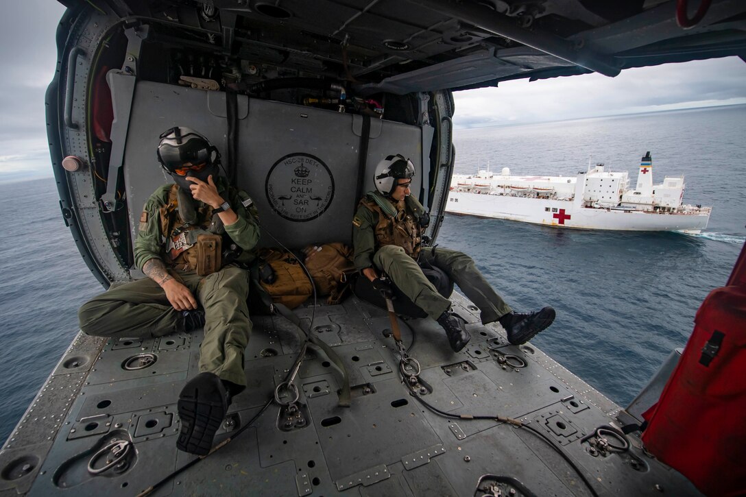 A Navy crewman aboard a helicopter.