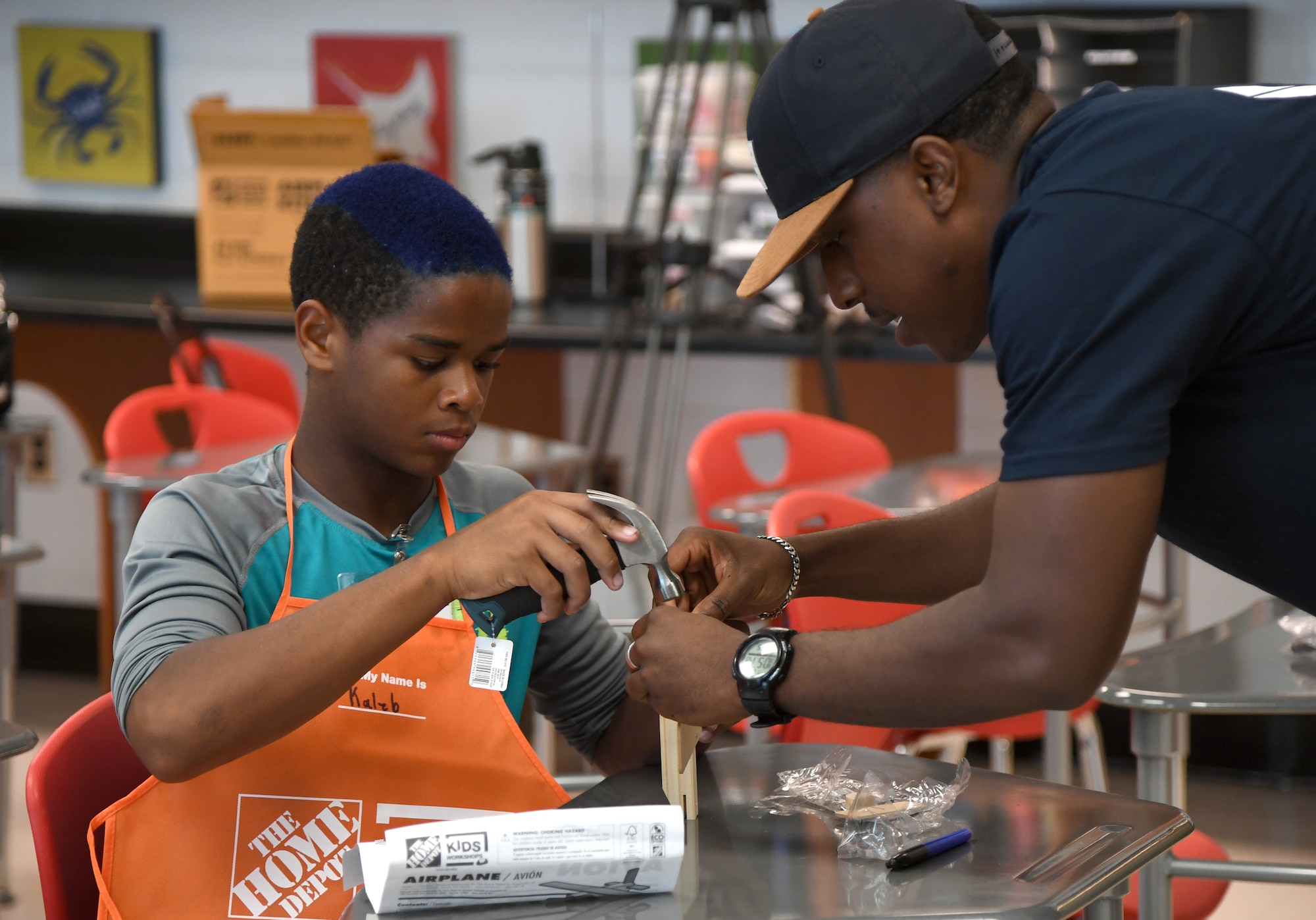 U.S. Air Force Staff Sgt. Dequanzel Davis, 338th Training Squadron radio frequency transmissions systems instructor, and Kaleb Foggie, Biloxi Junior High School eighth grade student, assemble a wooden airplane during the Biloxi Public Schools Science, Technology, Engineering and Mathematics Summer Camp program at Biloxi High School in Biloxi, Mississippi, June 25, 2019. The four-day STEM summer program teaches first through seventh grade students skills for future careers and fosters valuable life skills like problem solving, creativity and collaboration. Keesler personnel volunteered their time to lead instructions on various projects. (U.S. Air Force photo by Kemberly Groue)