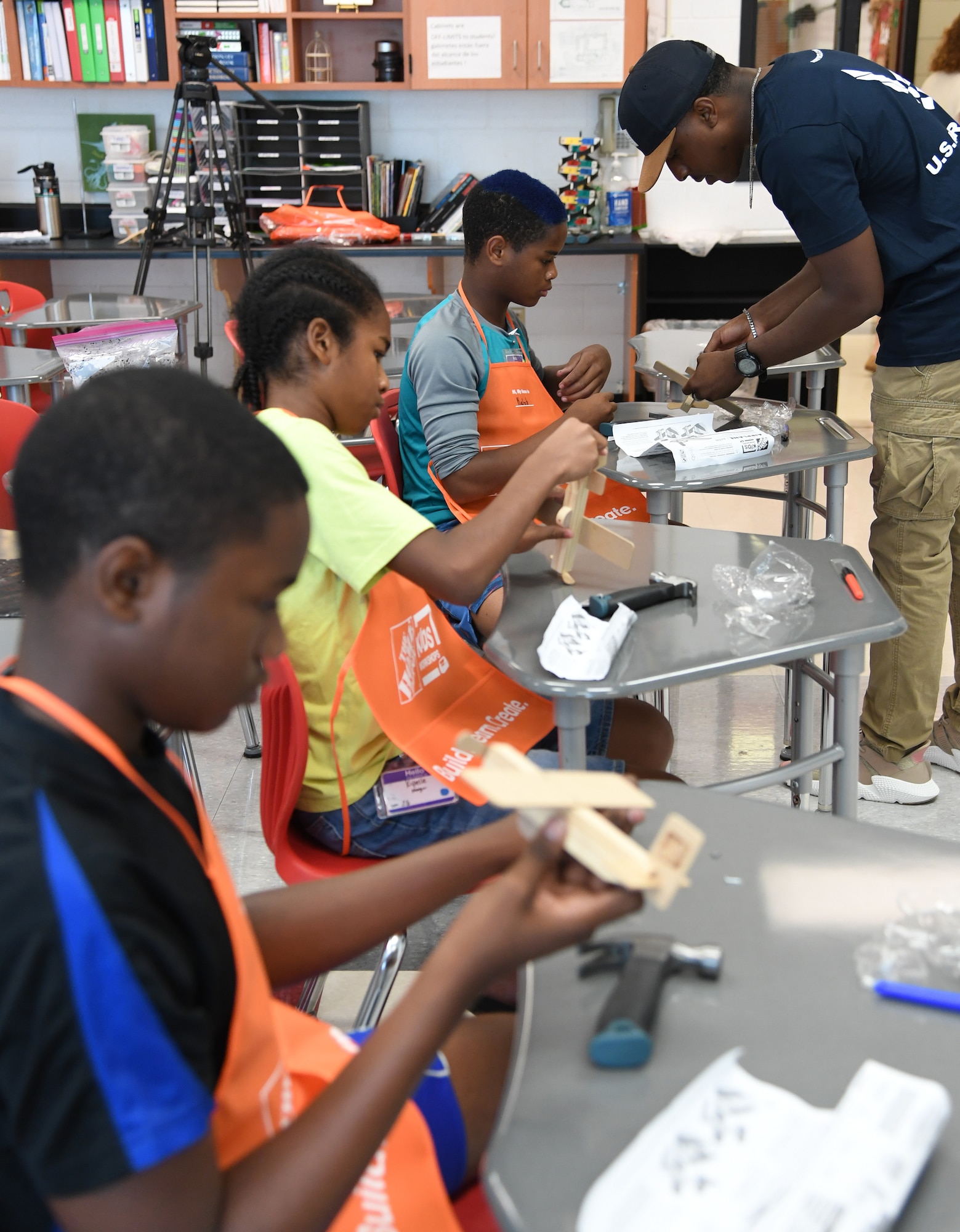U.S. Air Force Staff Sgt. Dequanzel Davis, 338th Training Squadron radio frequency transmissions systems instructor, and Kaleb Foggie, Biloxi Junior High School eighth grade student, assemble a wooden airplane during the Biloxi Public Schools Science, Technology, Engineering and Mathematics Summer Camp program at Biloxi High School in Biloxi, Mississippi, June 25, 2019. The four-day STEM summer program teaches first through seventh grade students skills for future careers and fosters valuable life skills like problem solving, creativity and collaboration. Keesler personnel volunteered their time to lead instructions on various projects. (U.S. Air Force photo by Kemberly Groue)