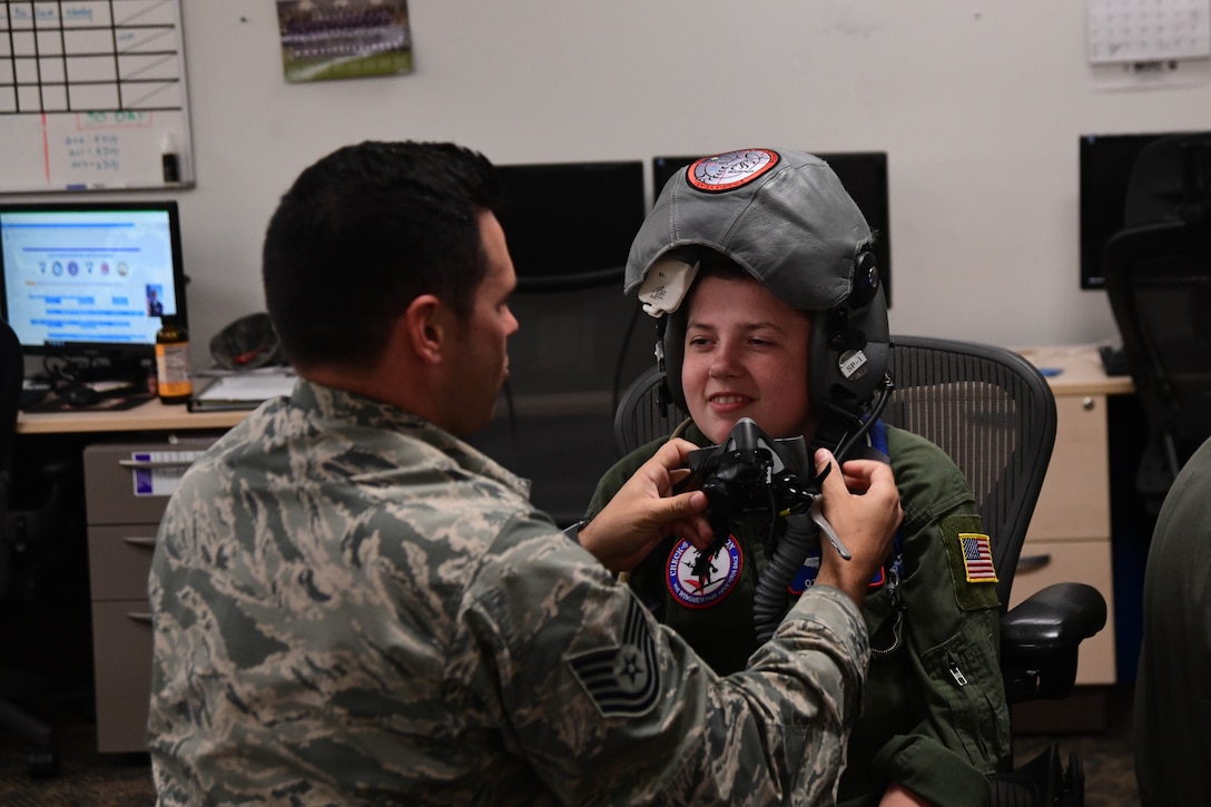 O’Rian Jolley, The Check-6 Foundation pilot for a day, tries on an F-16 fighter pilot helmet during his visit to the 113th Operations Group on Joint Base Andrews, June 26, 2019.  As an honorary pilot, O’Rian visited different units on the base to get an up close experience with helicopters, jet aircraft and flying simulators, learning from military and civilian volunteers about their missions on JBA. (U.S. Air National Guard photo by Erica Flores)