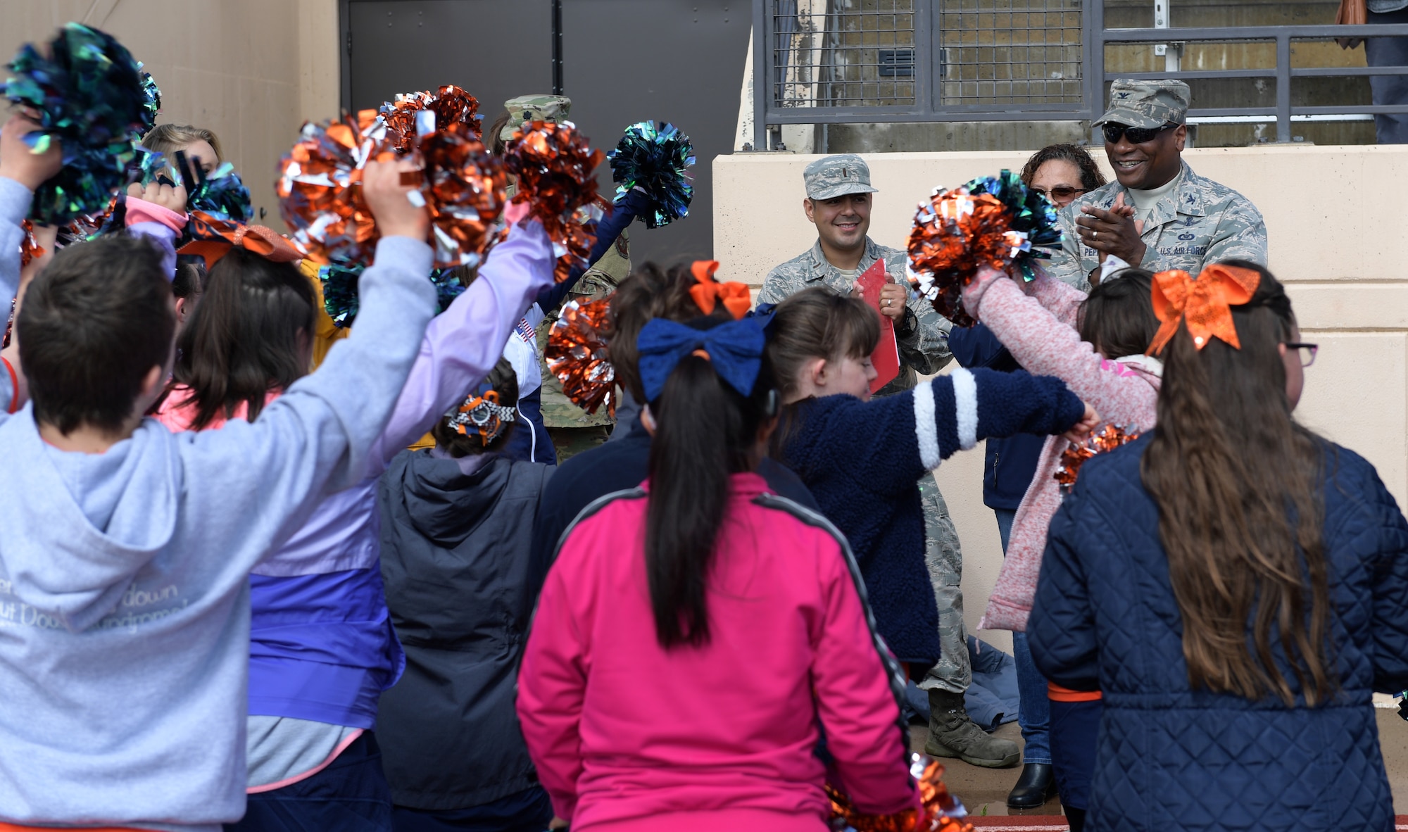 Col. Devin Pepper, right, 460th Space Wing commander, gives a speech to the cheerleaders prior to the start of the Dare to Play football game June 22, 2019, in Highlands Ranch, Colorado.