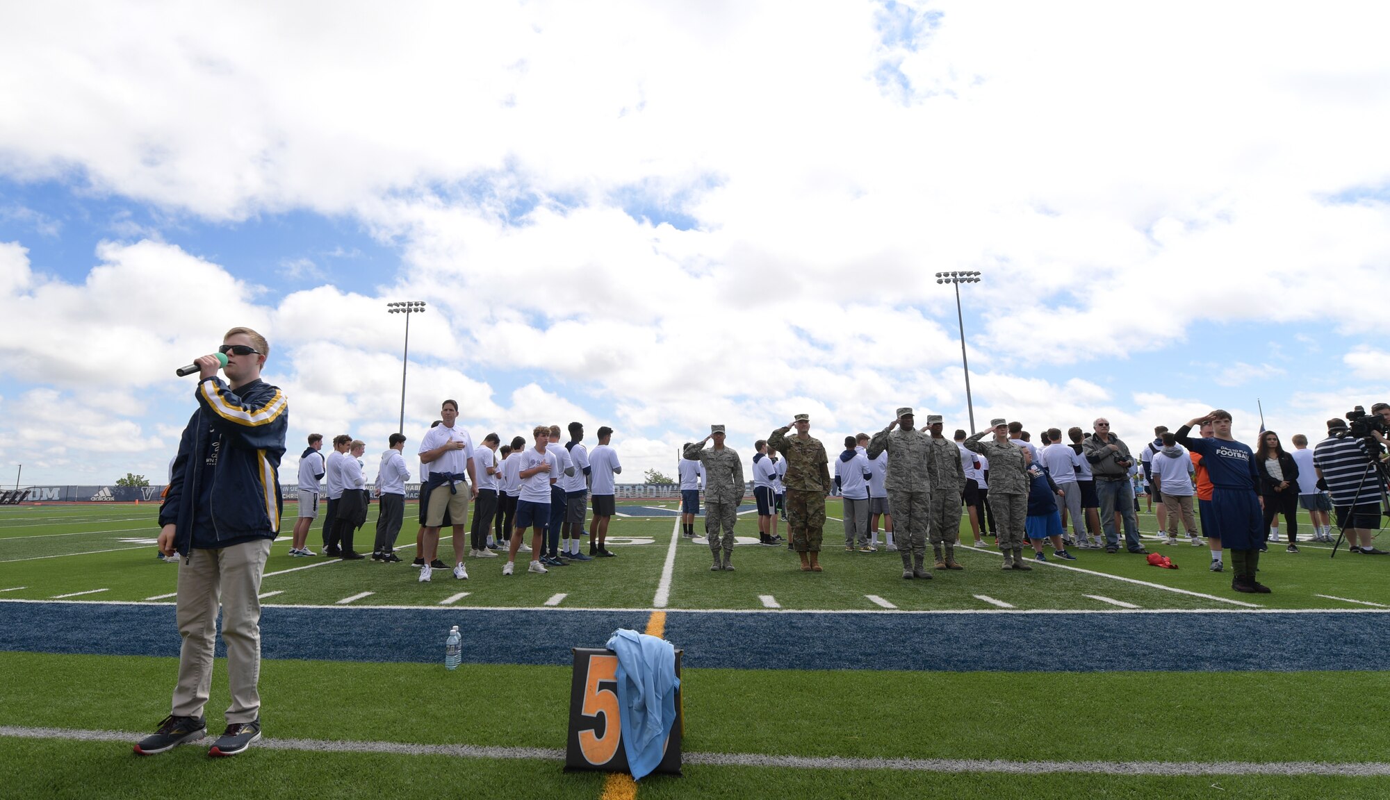 Conor Long sings the national anthem as members of Team Buckley render a salute June 22, 2019, in Highlands Ranch, Colorado.