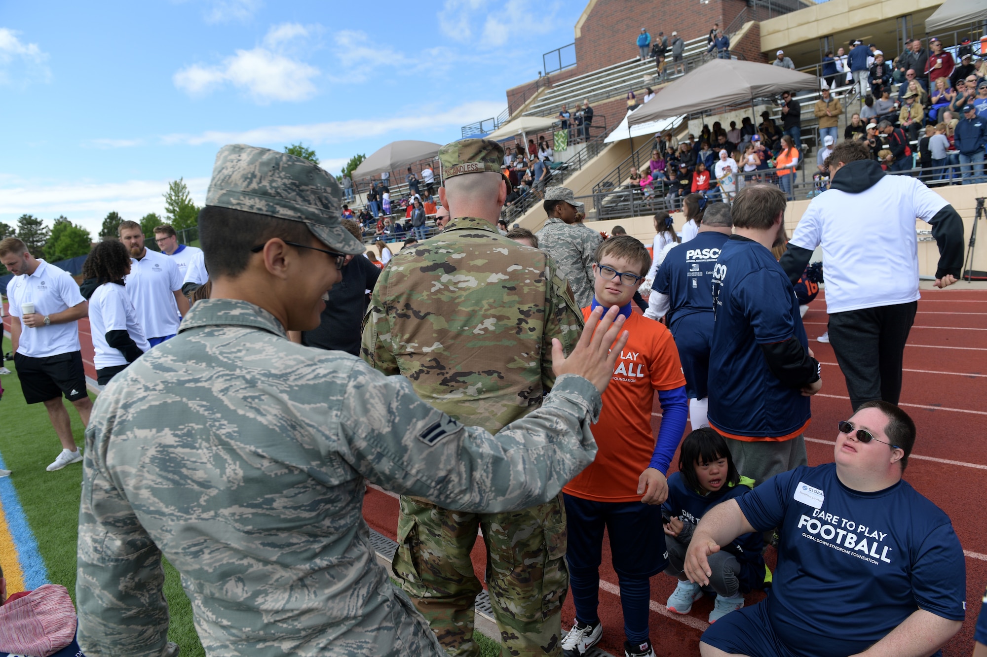 Airman 1st Class Darien Concepcion, 2nd Space Warning Squadron space systems operator, congratulates one of the players following the Dare to Play football game June 22, 2019, in Highlands Ranch, Colorado.