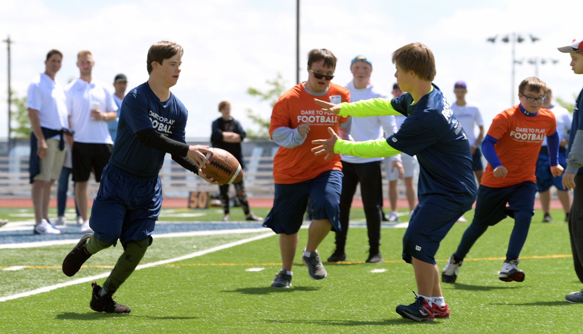 A player with the Blue Team passes the ball to his teammate during the Dare to Play football event June 22, 2019, in Highlands Ranch, Colorado.