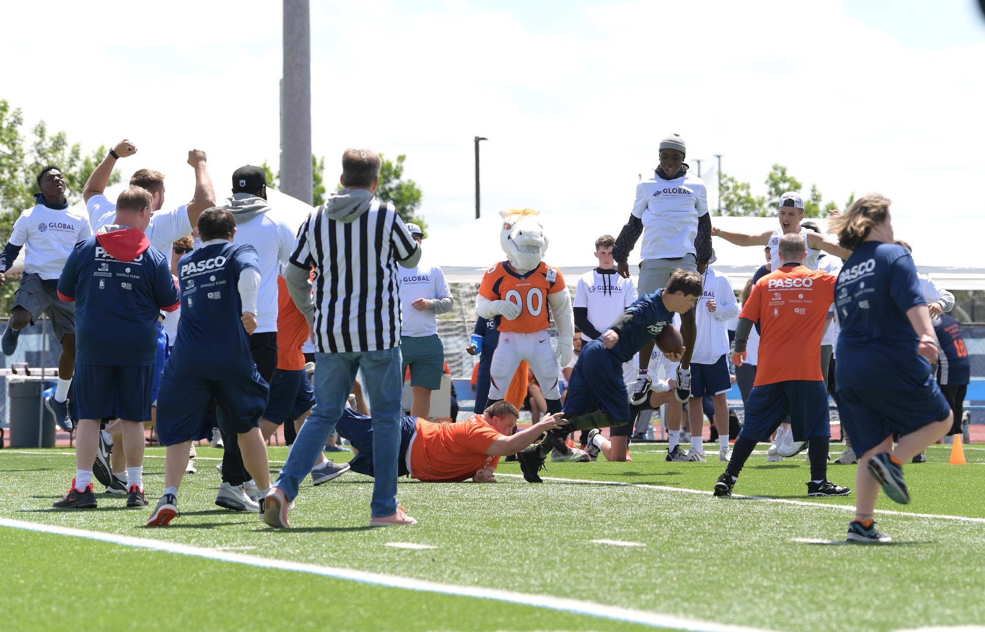 A player with the Orange Team tackles his opponent during the Dare to Play football event June 22, 2019, in Highlands Ranch, Colorado.