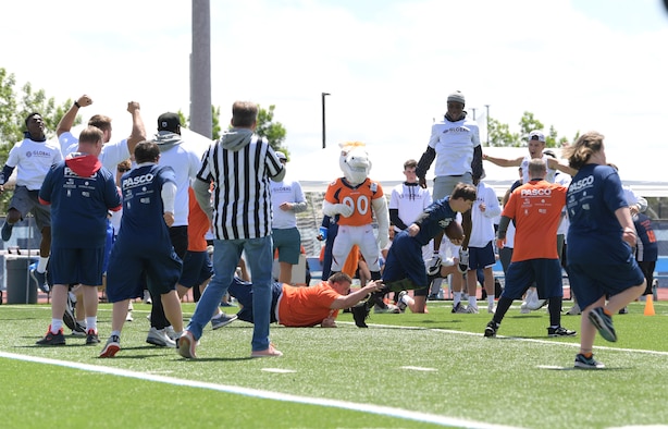 A player with the Orange Team tackles his opponent during the Dare to Play football event June 22, 2019, in Highlands Ranch, Colorado.