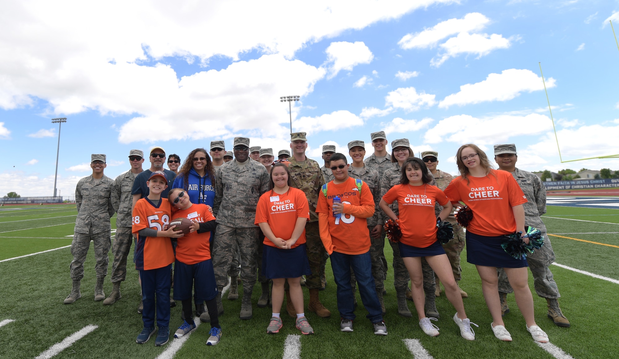 Members of Team Buckley pose for a group photo with players and cheerleaders following the 10th annual Dare to Play football event June 22, 2019, in Highlands Ranch, Colorado.