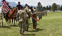 Lt. Col. Donald Brooks, outgoing 1st Space Battalion commander, and 1st Space Battalion Command Sgt. Maj. Tracey Rosser attach the U.S. Army Superior Unit Award streamer to the battalion guidon June 26 prior to Brooks’ change of command ceremony at Fort Carson, Colorado. The award recognizes outstanding meritorious performance by a unit during peacetime, in which they display meritorious performance of a difficult and challenging mission carried out under extraordinary circumstances. (U.S. Army photo by Dottie White)