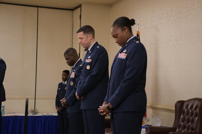 Left to right, Col. Adams, Lt. Col. Brian Collins and Maj. Jahayra N. Lowe bow their heads in prayer during the opening of the 628th Comptroller Squadron change of Command, June 27, 2019, at Joint Base Charleston, S.C. The squadron bid farewell to Collins, the outgoing commander, and welcomed Lowe as the new squadron commander. The change of command ceremony acts as a formal transfer of responsibility, authority and accountability from the outgoing to incoming commander.