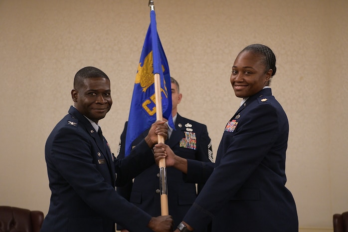 Col. Terrence Adams, 628th Air Base Wing commander, passes the 628th Comptroller Squadron guidon to Maj. Jahayra N. Lowe, 628th CPTS commander June 27, 2019 at Joint Base Charleston, S.C. The squadron bid farewell to Lt. Col. Bryan Collins, the outgoing commander, and welcomed Lowe as the new squadron commander. The passing of the guidon is a ceremonious representation of an incoming commander's assumption of command. The change of command ceremony acts as a formal transfer of responsibility, authority and accountability from the outgoing to incoming commander.