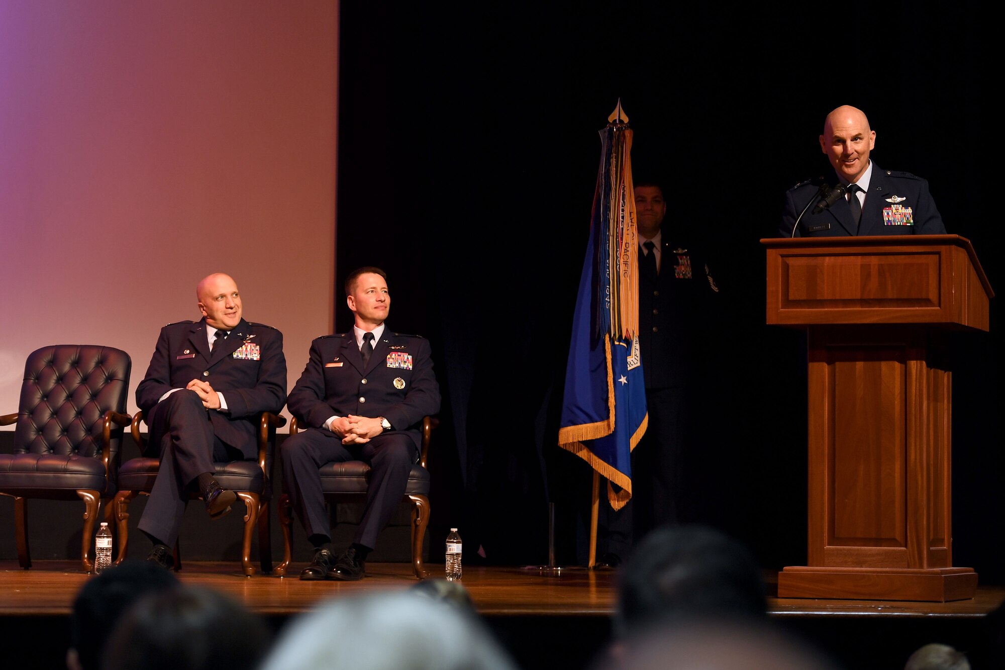 An Airman hands flowers to the new commnaders wife.