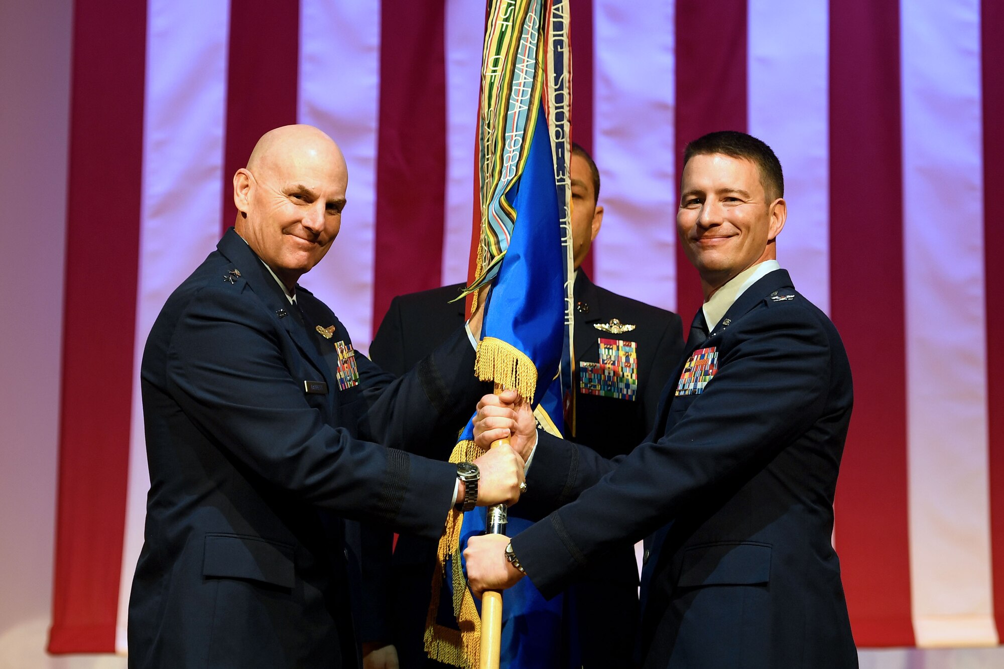 An Airman hands flowers to the new commnaders wife.