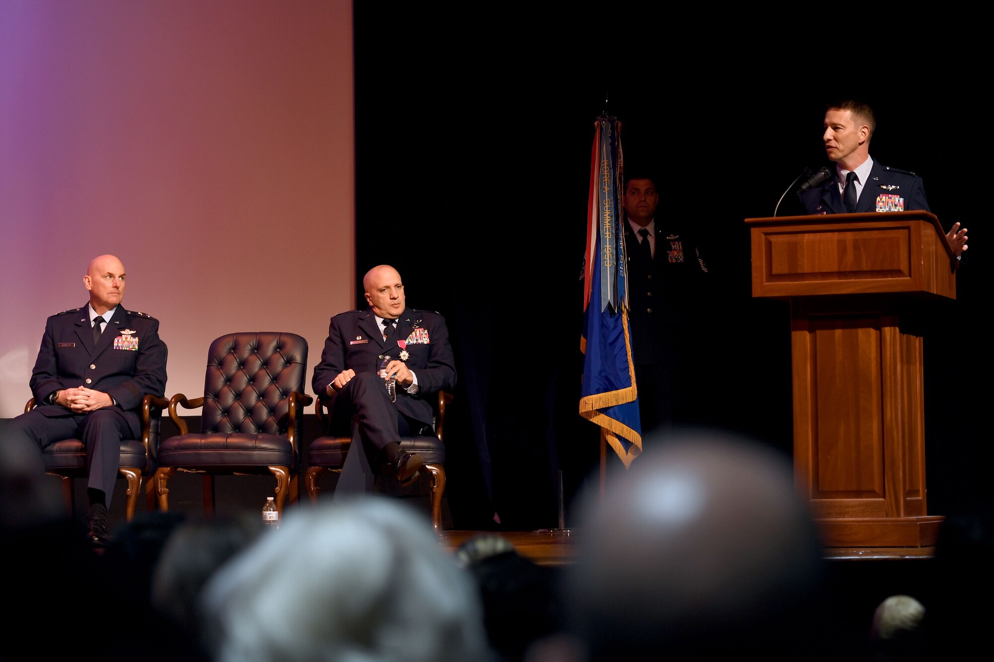 Four Airmen stand on stage during a ceremony