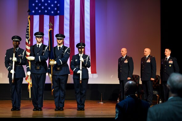 Four Airmen stand on stage during a ceremony