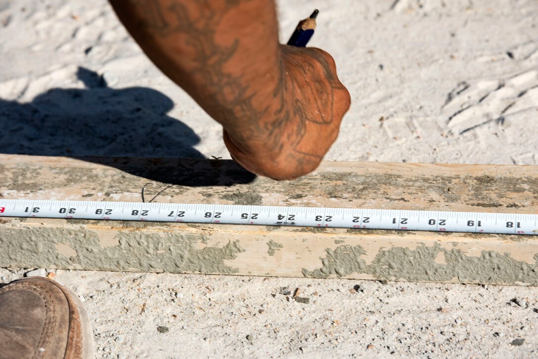 Louis Quiroga, construction worker, makes a measurement during a storm-drain construction project, June 26, 2019, at Moody Air Force Base, Ga. The construction will rebuild three curb-inlets and reinforce storm-drain piping to improve the draining system and allow rain water to flow into a local creek. (U.S. Air Force photo by Senior Airman Erick Requadt)