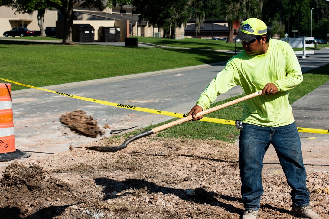 Moses Meseiza, construction worker, applies dirt to a curb-inlet frame during a storm-drain construction project, June 26, 2019, at Moody Air Force Base, Ga. The construction will rebuild three curb-inlets and reinforce storm-drain piping to improve the draining system and allow rain water to flow into a local creek. (U.S. Air Force photo by Senior Airman Erick Requadt)