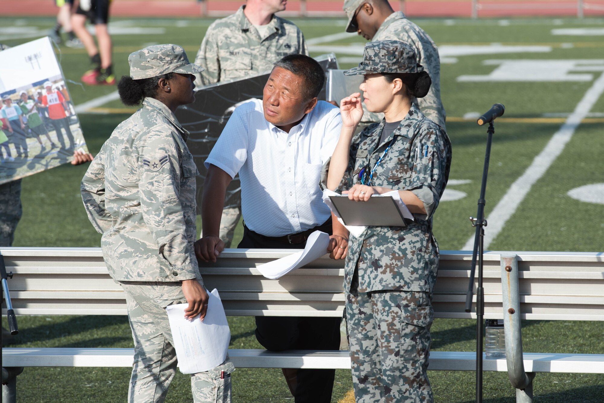 (Center) Yoichi Akimoto, a member of the Kanto Plains Special Olympics committee, talks to emcees after the opening ceremony rehearsal, May 30, 2019, at Yokota Air Base, Japan.