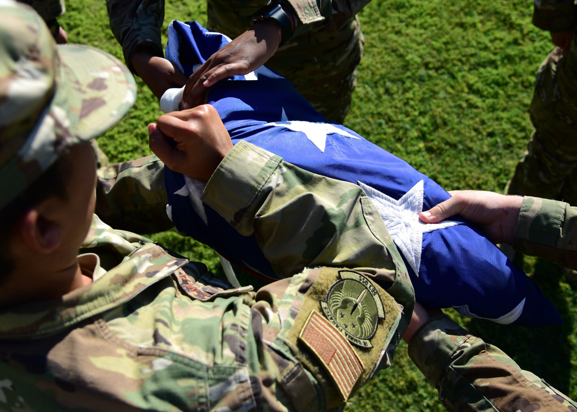 Airmen assigned to the 563d Rescue Group fold the flag during a retreat ceremony at Davis-Monthan Air Force Base, Ariz., June 27, 2019. These Airmen were responsible for the flag detail portion of this ceremony which included lowering and folding the flag.