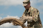 Staff Sgt. Joshua Baird, a military police Soldier attached to Headquarters Headquarters Company, 734th Regional Support Group (RSG), Iowa Army National Guard, works with concertina wire to secure a forward operating base during operation Saber Guardian 2019 at Cincu Training Center, Cincu, Romania, on June 4, 2019.