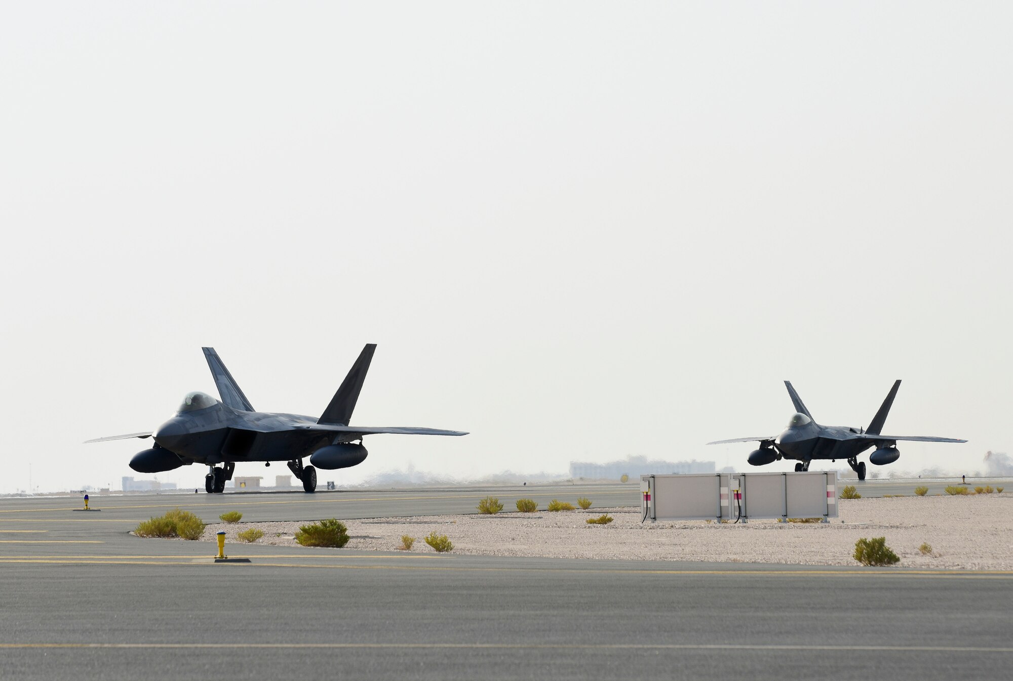 A photo of F-22s taxiing on a runway.