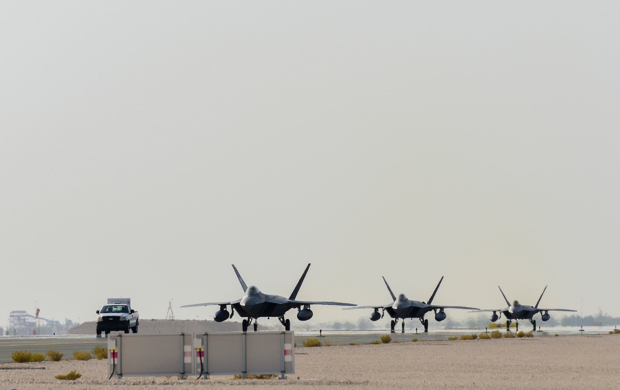 A photo of F-22s taxiing down a runway.