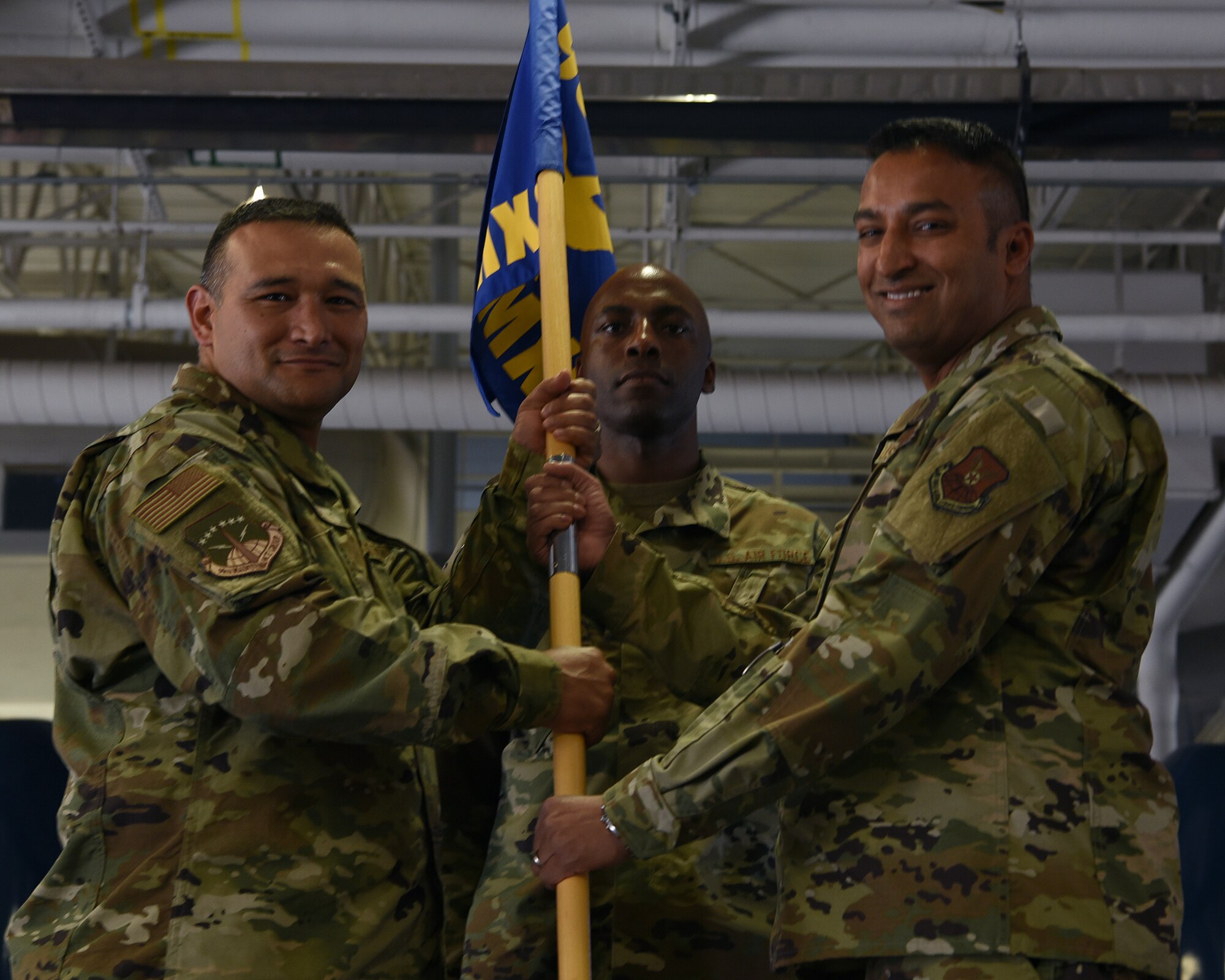Colonel Brian Rico, 90th Maintenance Group commander, passes the guidon to Maj. Aaron Taylor, 790th Maintenance Squadron incoming commander, during the 790ths MXS change of command ceremony June 27, 2019, on F.E. Warren Air Force Base, Wyo. The ceremony signified the transition of command from Maj. Christine Hernandez to Taylor (U.S. Air Force photo by Senior Airman Nicole Reed)
