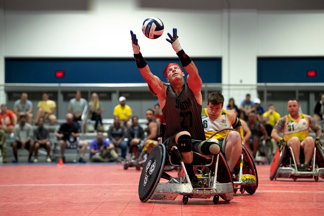 A man in a wheelchair catches a pass.