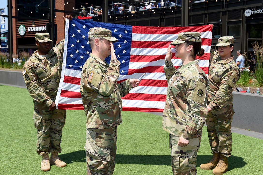 Sgt. Maribel Meraz, right, assigned to the 85th U.S. Army Reserve Support Command, headquartered in the northwest suburbs of Chicago, states the Oath of Enlistment at Gallagher Way, adjacent to the Chicago Cubs Wrigley Field, June 27, 2019, for a third six-years in the Army Reserve.