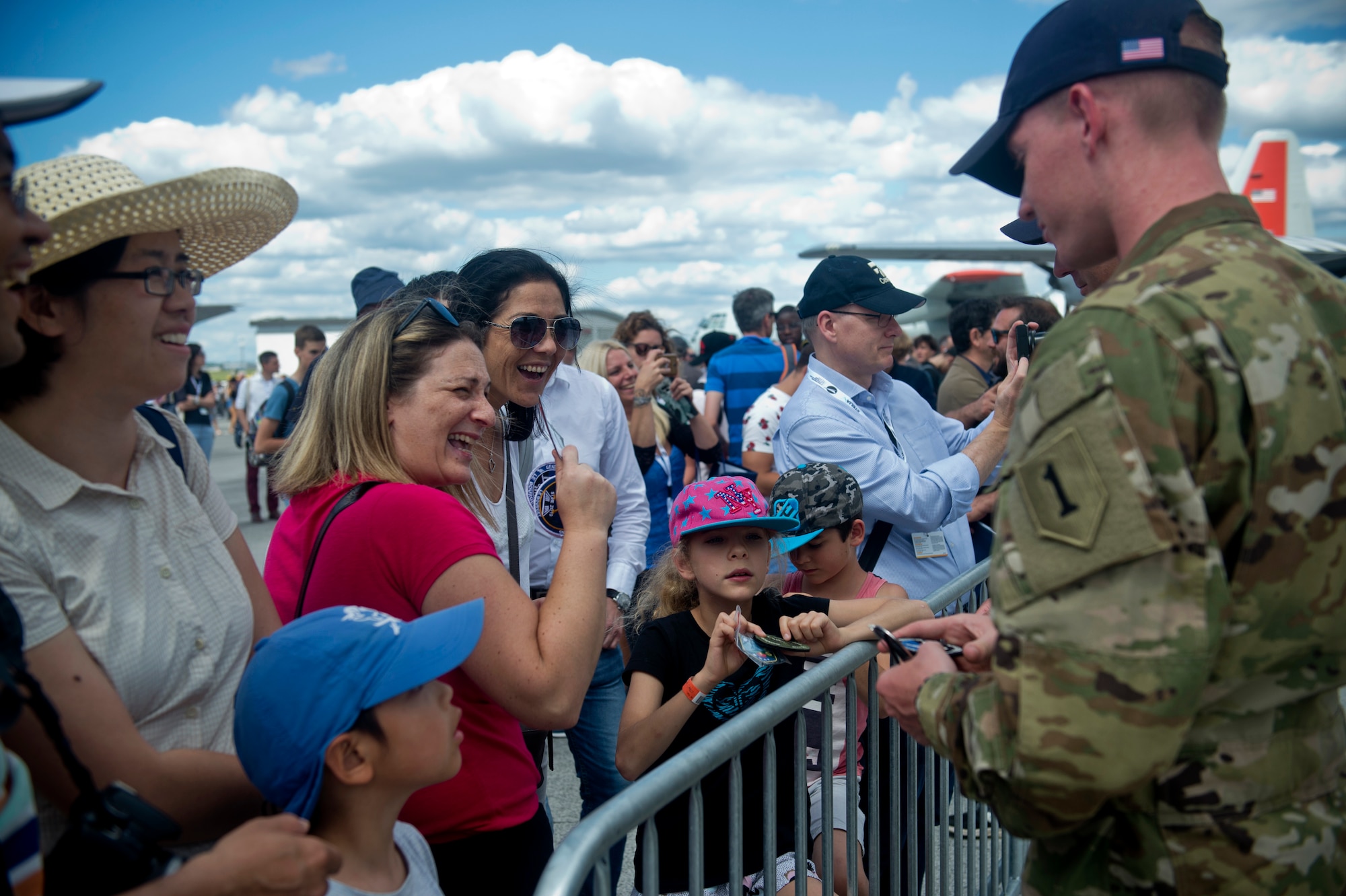 U.S. Army 1st Lt. Ryan Johnson, Bravo Troop, 1st Squadron, 6th Cavalry Regiment, 1st Combat Aviation Brigade, 1st Infantry Division, stationed at Fort Riley, Kan., trades patches with visitors to the Paris Air Show, June 21, 2019. The air show provided a collaborative opportunity to share and strengthen U.S. and strategic international partnerships. (U.S. Air Force photo by Master Sgt. Eric Burks)