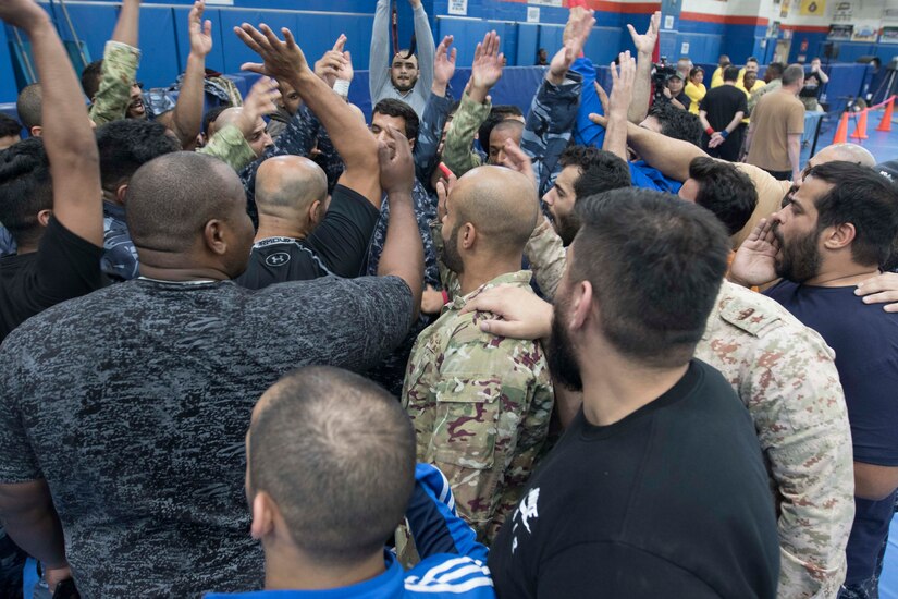 Kuwaiti armed forces participate in a team huddle before a combatives tournament at Camp Arifjan, Kuwait, June 23, 2019. U.S. Army Central hosts events such as the combatives tournament to strengthen its relationship and build partner capacity with the Kuwaitis. USARCENT operates throughout the Middle East region and appreciates the generosity of the host nation’s willingness to maintain bilateral defense relationships.