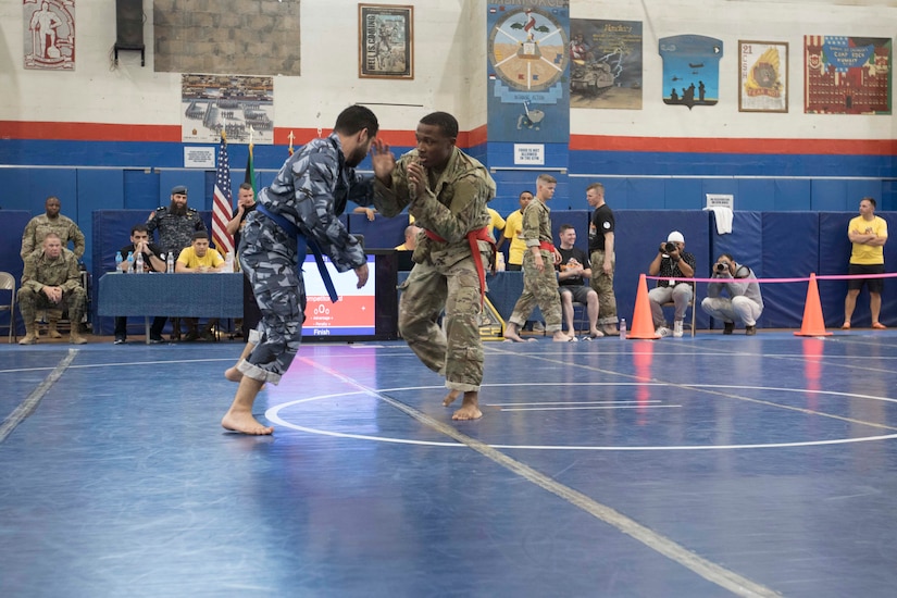 United States Army Spc. Luciano Thomas, right, a signal support systems specialist assigned to 18th Field Artillery Brigade, Headquarters and Headquarters Battery, competes in a combatives tournament at Camp Arifjan, Kuwait, June 23, 2019. U.S. Army Central hosts events such as the combatives tournament to strengthen its relationship and build partner capacity with the Kuwaitis. USARCENT operates throughout the Middle East region and appreciates the generosity of the host nation’s willingness to maintain bilateral defense relationships.