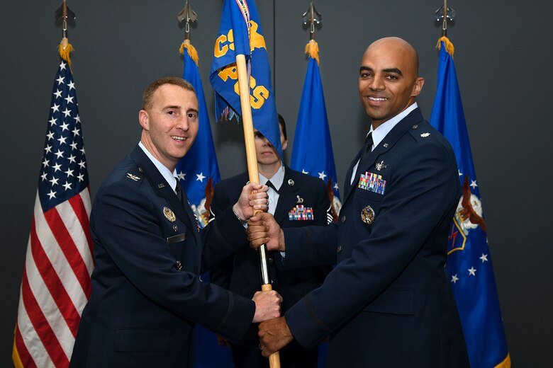 PETERSON AIR FORCE BASE, Colo. – Col. Matthew Cantore (left), 21st Operations Group commander, presents the guidon to Lt. Col. Angelo Fernandez (right), 16th Space Control Squadron commander, during a change of command ceremony June 25, 2019 at Peterson Air Force Base, Colorado. The passing of the guidon represents a formal transfer of authority and responsibility from an outgoing commander to an incoming one, ensuring that the unit and its Airmen are never without leadership. (U.S. Air Force photo by Craig Denton)