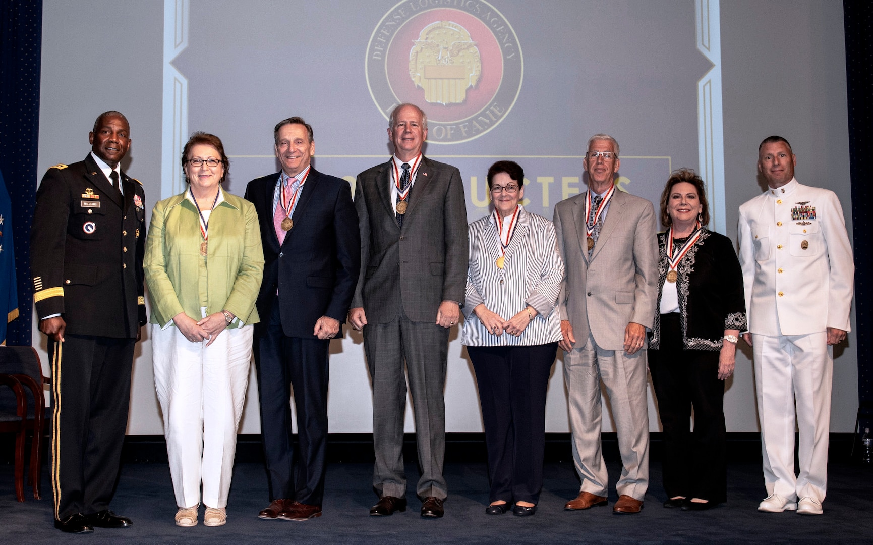 Five men and three women pose onstage at the 2019 DLA Hall of Fame ceremony.