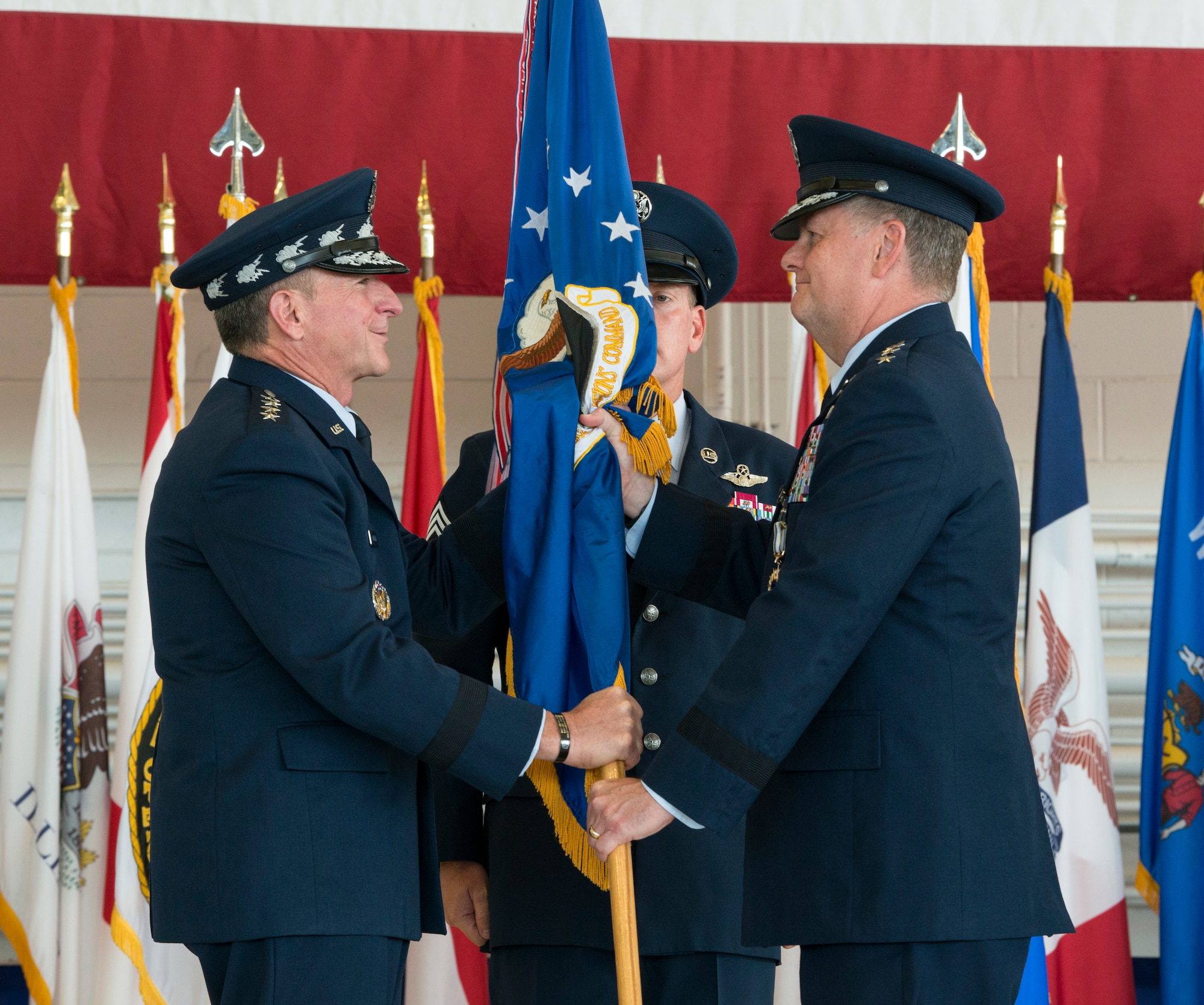 One person presenting a flag to another person.