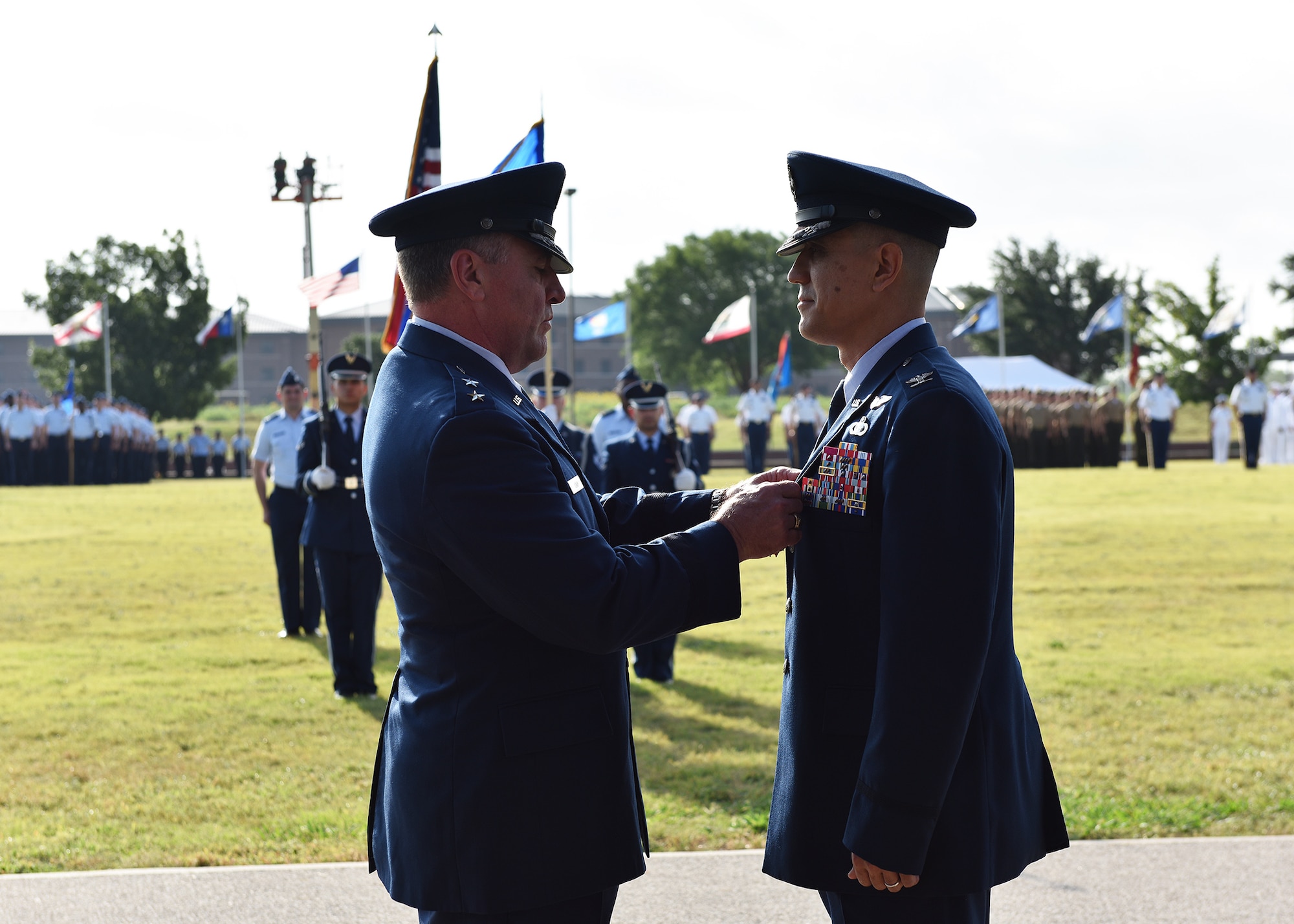 U.S. Air Force Maj. Gen. Timothy Leahy, Second Air Force commander, presents the Legion of Merit to the outgoing commander, Col. Ricky Mills, during the 17th Training Wing change of command ceremony at the parade field on Goodfellow Air Force Base, Texas, June 28, 2019. Mills is moving to Maxwell Air Force Base, Ala., where he will serve as the commandant of the Squadron Officer School. (U.S. Air Force photo by Staff Sgt. Chad Warren/Released)