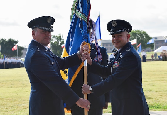 U.S. Air Force Maj. Gen. Timothy Leahy, Second Air Force commander, presents the guidon to incoming commander, Col. Andres Nazario, during the 17th Training Wing change of command ceremony at the parade field on Goodfellow Air Force Base, Texas, June 28, 2019. Leahy presided over the ceremony, in which Col. Ricky Mills relinquished command of the 17th TRW. (U.S. Air Force photo by Staff Sgt. Chad Warren/Released)