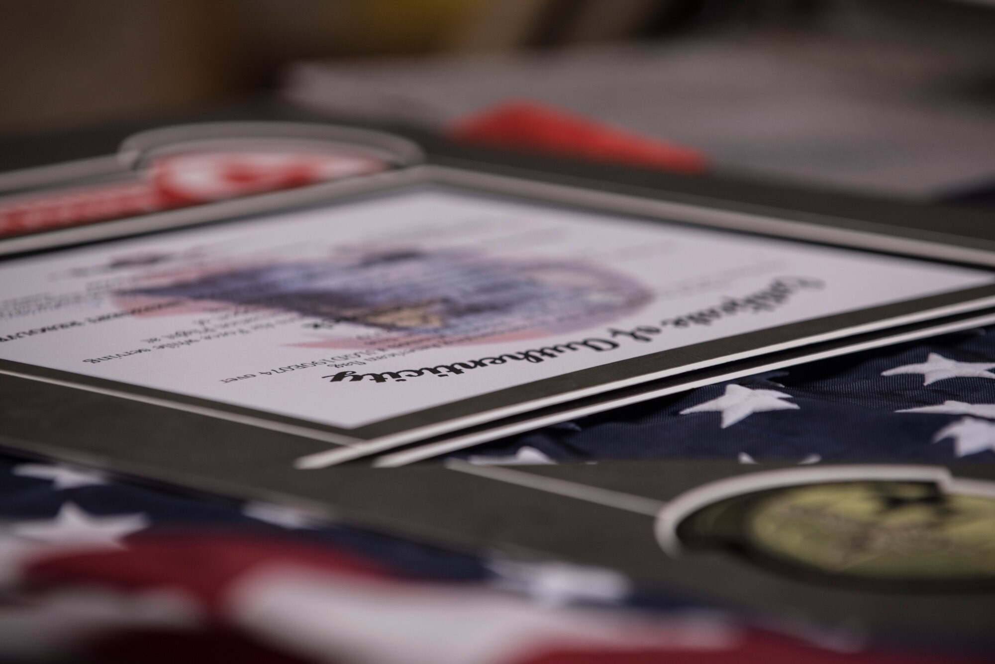 The almost completed shadow box is placed on a table before the custom built frame is added June 27, 2018, on F.E. Warren Air Force Base, Wyo. When an occasion calls for something special, the employees have numerous ways for someone to express themselves. (U.S. Air Force photo by Senior Airman Abbigayle Williams)