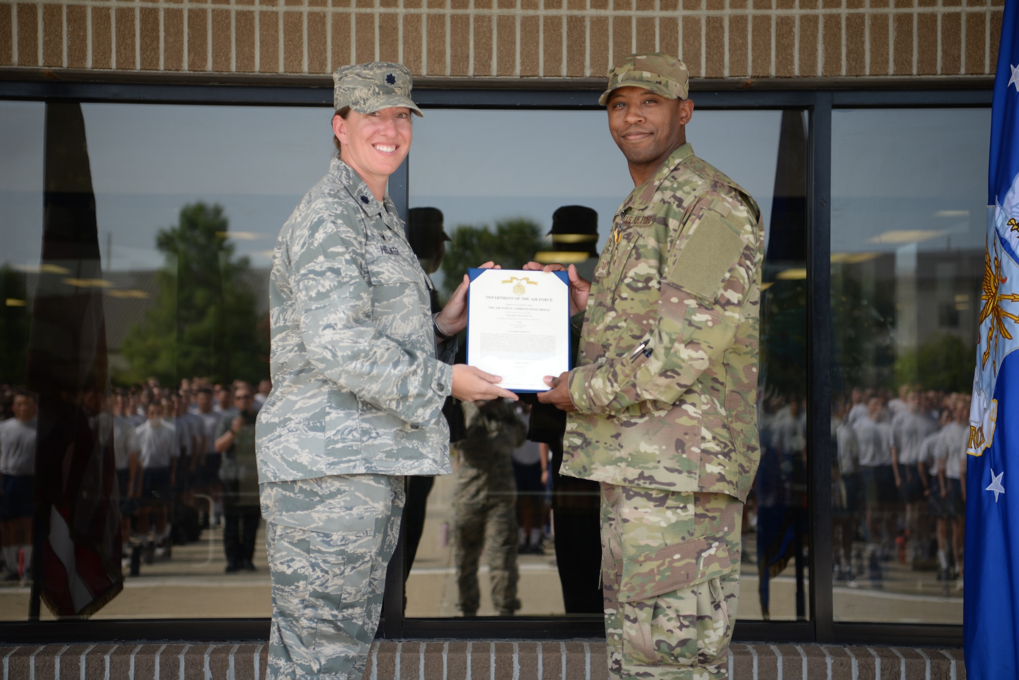 U.S. Air Force Lt. Col. Jill Heliker, 336th Training Squadron commader, and Tech. Sgt. Jonathan Collett, 336th Training Squadron cyber surety student, pose for a photo outside the Levitow Training Support Facillity on Keesler Air Force Base, Mississippi, June 27, 2019. Collett recieved an Air Force Commendation Medal for saving Dennis Boney, Harrison County Police Department deputy, after an accident that injured his leg. (U.S Air Force photo by Airman 1st Class Spencer Tobler)